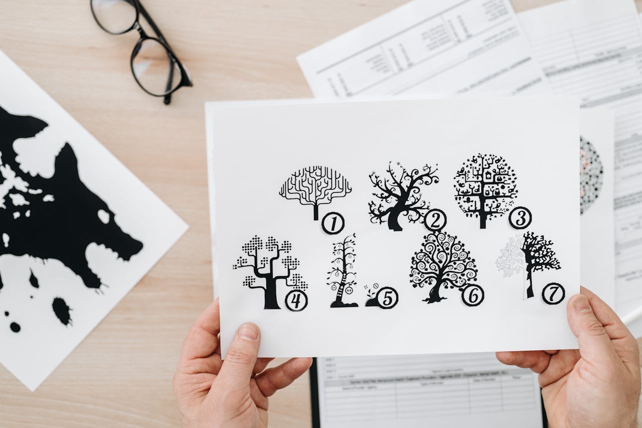 Services-01 Close-up showing hands holding paper with tree test illustration for psychological assessment.